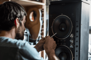 gefen_23233_a_man_fixing_a_speaker_with_a_blank_bright_backgrou_c24187b7-f649-4aa2-be20-91126a00707d-2